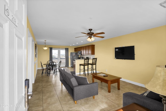 tiled living room featuring french doors and ceiling fan