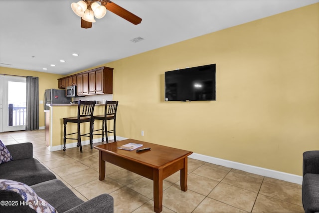 tiled living room with ceiling fan