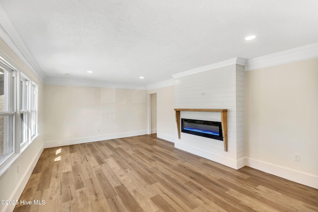 unfurnished living room with crown molding and light hardwood / wood-style flooring