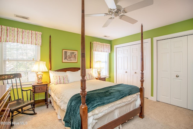 carpeted bedroom with ceiling fan and multiple closets