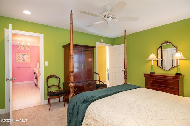 carpeted bedroom featuring ceiling fan with notable chandelier and connected bathroom