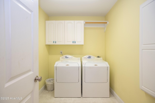 laundry area with independent washer and dryer and cabinets