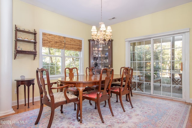 dining room with hardwood / wood-style floors, a chandelier, and a healthy amount of sunlight