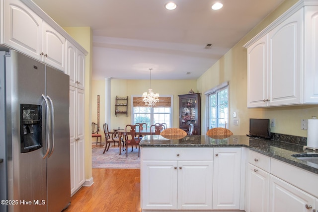 kitchen featuring white cabinetry, stainless steel fridge with ice dispenser, a notable chandelier, and hanging light fixtures