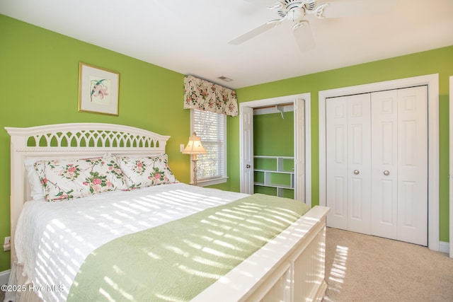 bedroom featuring ceiling fan, two closets, and light colored carpet