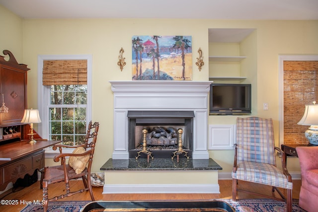 living area featuring light hardwood / wood-style floors and built in shelves