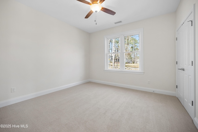 carpeted spare room featuring ceiling fan