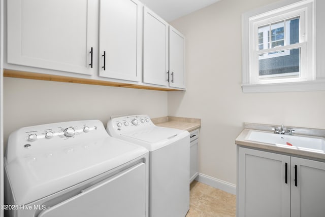 laundry room with washer and dryer, cabinets, light tile patterned floors, and sink