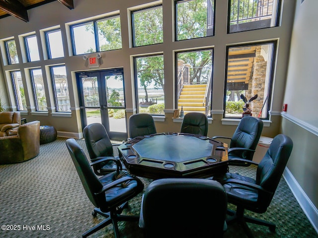 carpeted office with beamed ceiling and a towering ceiling