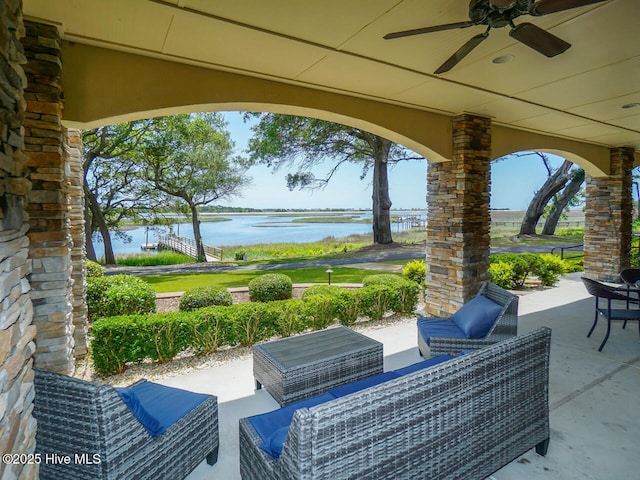 view of patio with ceiling fan, a water view, and an outdoor living space