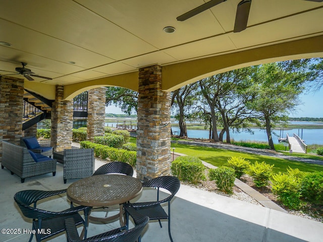 view of patio / terrace featuring ceiling fan and a water view