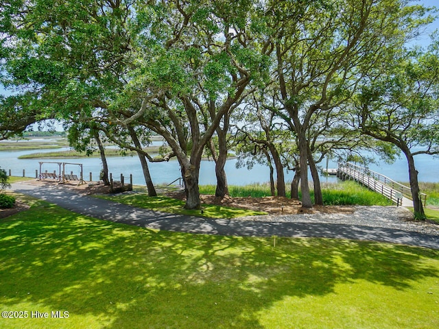 exterior space featuring a lawn and a water view