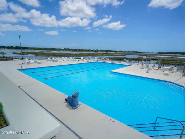 view of pool featuring a patio and a water view