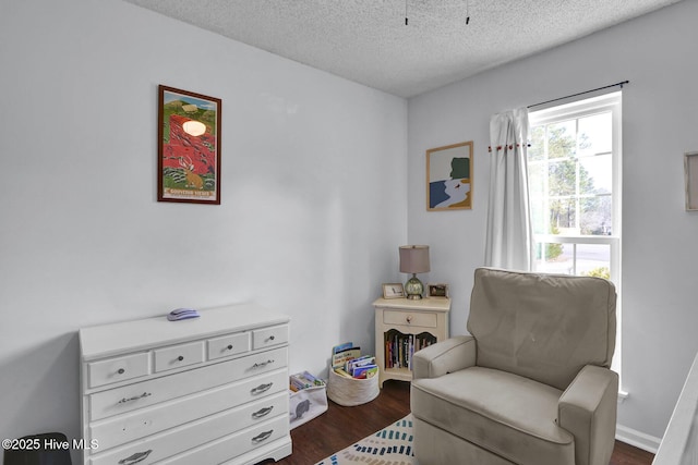 sitting room with dark wood-type flooring and a textured ceiling