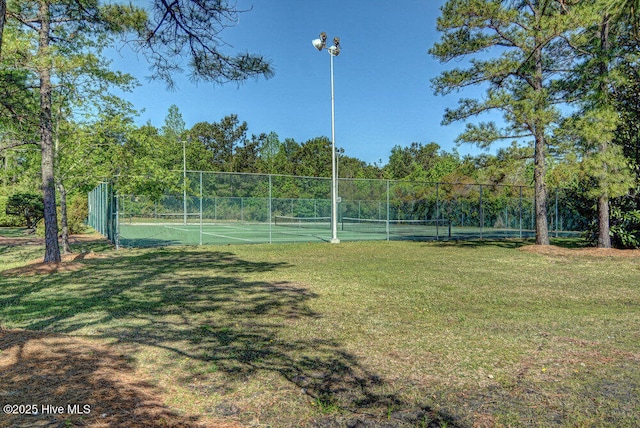 view of tennis court featuring a yard