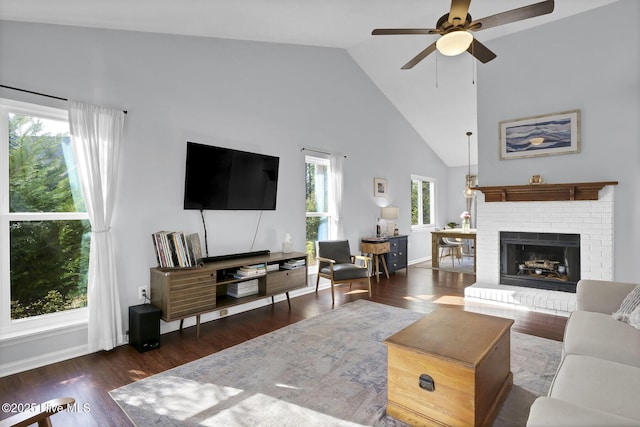 living room featuring ceiling fan, a brick fireplace, dark wood-type flooring, and high vaulted ceiling