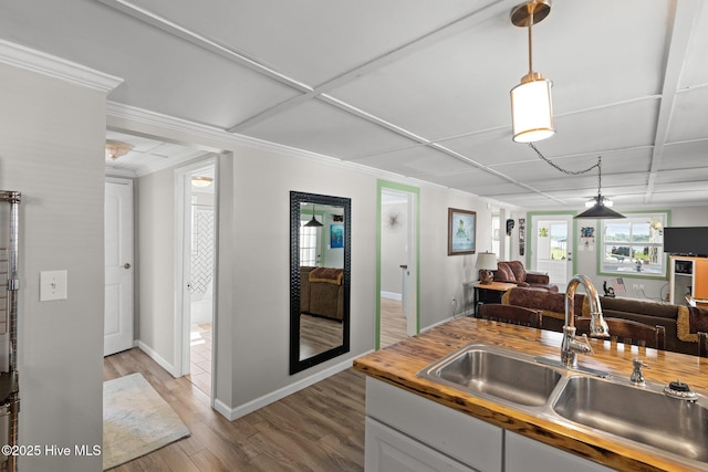 kitchen featuring hardwood / wood-style floors, white cabinetry, butcher block counters, and sink