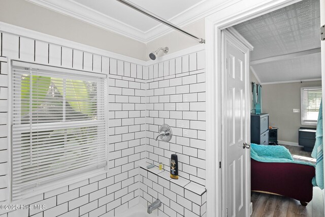 bathroom with crown molding, hardwood / wood-style floors, and tiled shower / bath combo