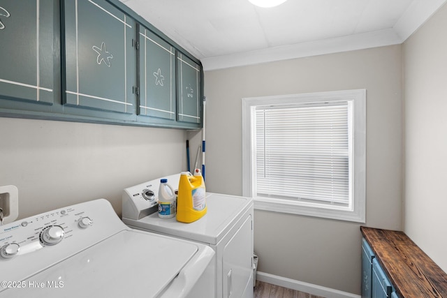 clothes washing area with washer and dryer, crown molding, cabinets, and hardwood / wood-style flooring