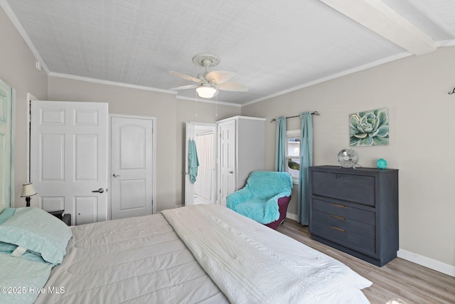 bedroom featuring beam ceiling, light hardwood / wood-style floors, ceiling fan, and ornamental molding