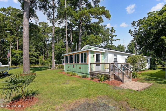 view of front of house with a deck and a front yard