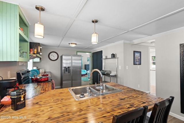 kitchen featuring sink, green cabinets, wooden counters, stainless steel refrigerator with ice dispenser, and stove