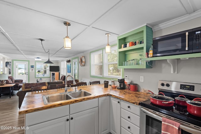 kitchen with a drop ceiling, stainless steel appliances, sink, white cabinetry, and butcher block counters