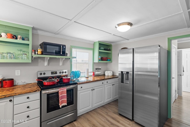 kitchen with butcher block counters, white cabinetry, stainless steel appliances, crown molding, and light hardwood / wood-style floors