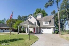 view of front of property featuring a front yard and a garage