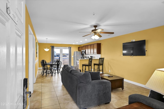 living room featuring ceiling fan and light tile patterned flooring