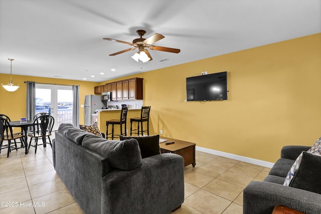 living room with ceiling fan and light tile patterned flooring