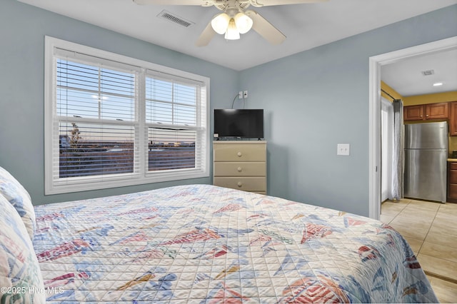 tiled bedroom with stainless steel fridge and ceiling fan