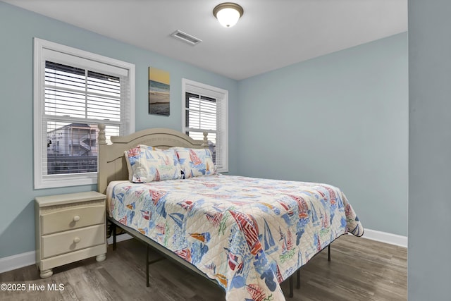 bedroom with dark hardwood / wood-style flooring