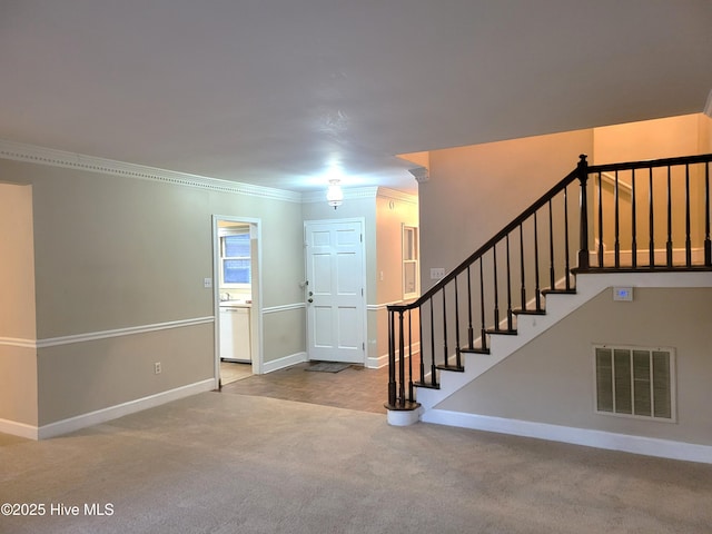 entrance foyer featuring visible vents, ornamental molding, stairway, carpet floors, and baseboards