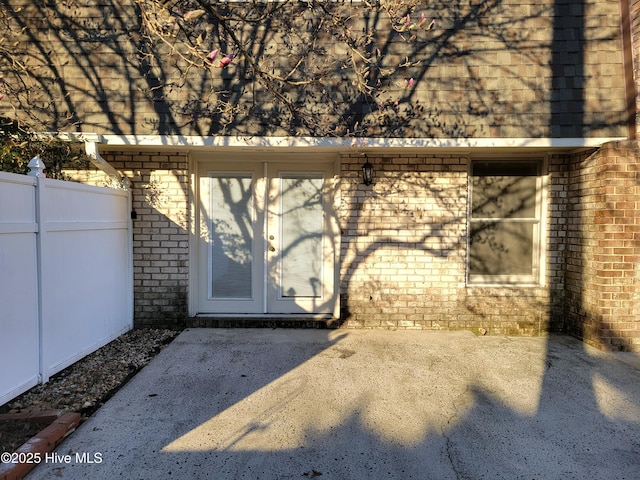 property entrance with brick siding and fence