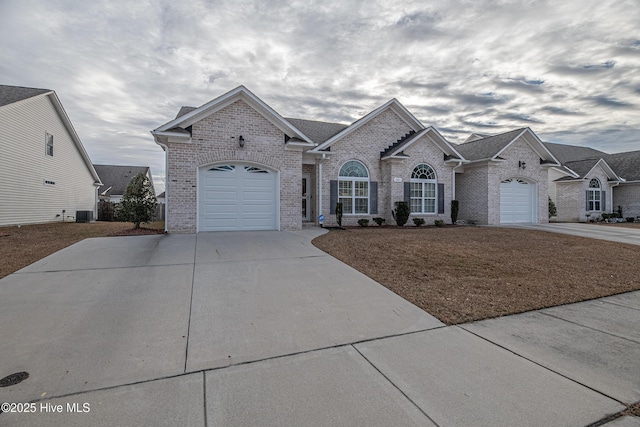 view of front of home with central AC unit and a garage