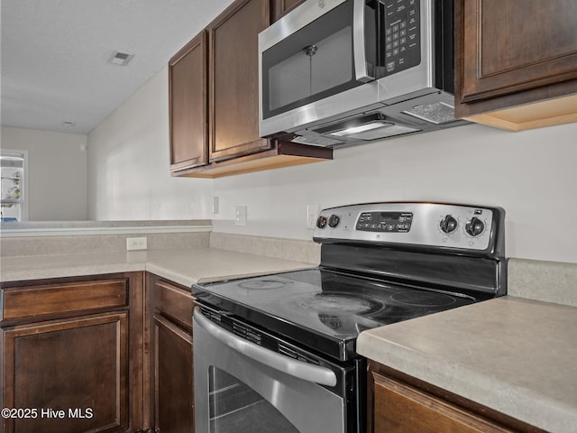 kitchen featuring stainless steel appliances and dark brown cabinets