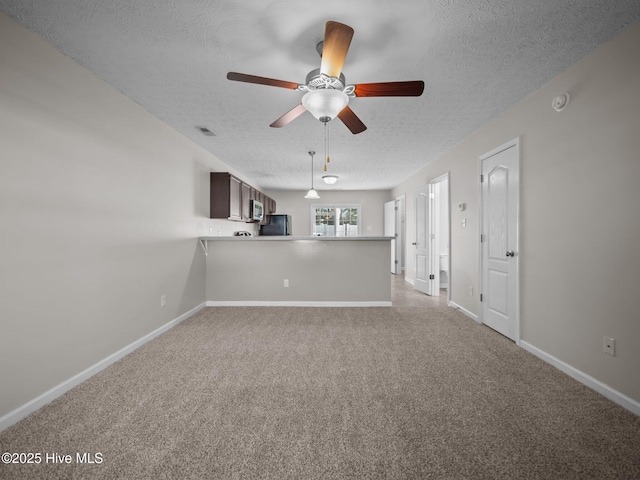 unfurnished living room with ceiling fan and a textured ceiling