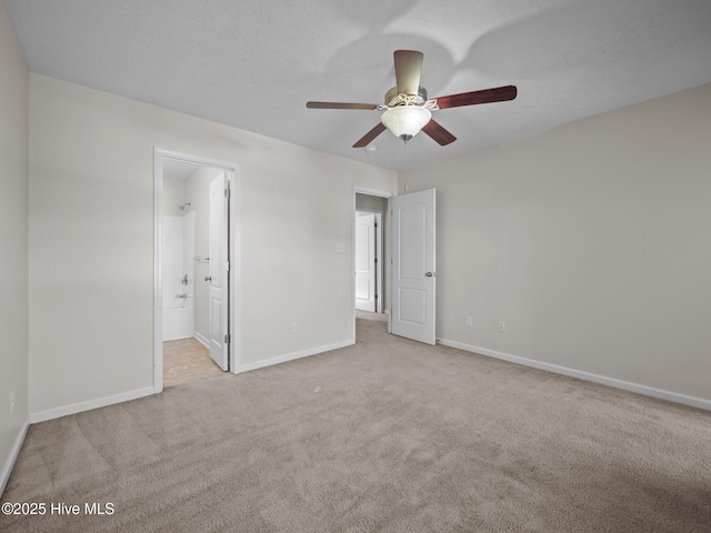 unfurnished bedroom featuring ensuite bathroom, ceiling fan, and light colored carpet