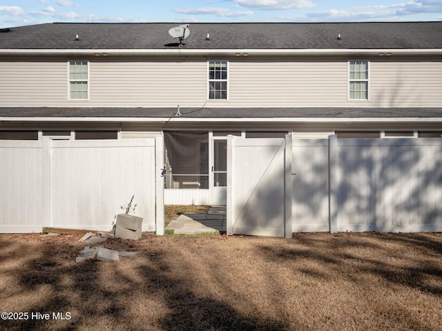 rear view of property featuring a sunroom