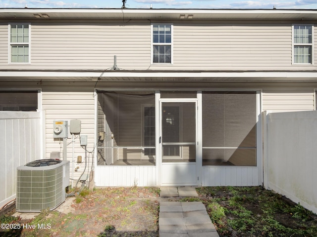 rear view of house featuring cooling unit and a sunroom