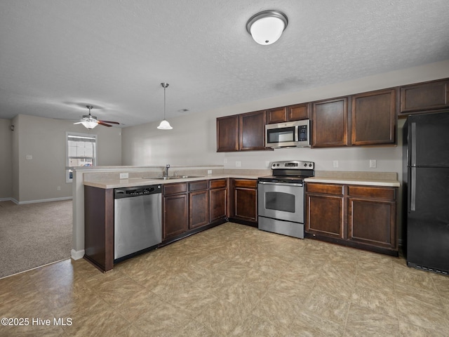 kitchen featuring sink, ceiling fan, kitchen peninsula, pendant lighting, and appliances with stainless steel finishes