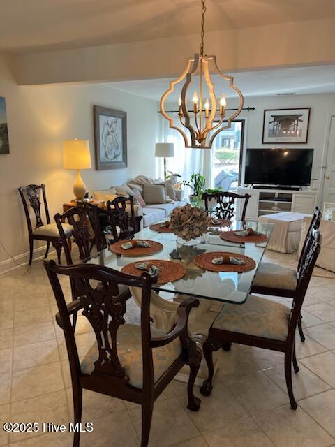 dining room with light tile patterned floors and a chandelier