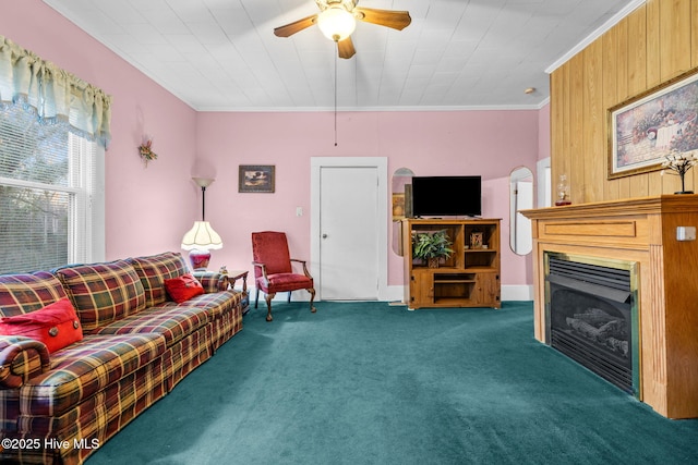 carpeted living room featuring crown molding and ceiling fan