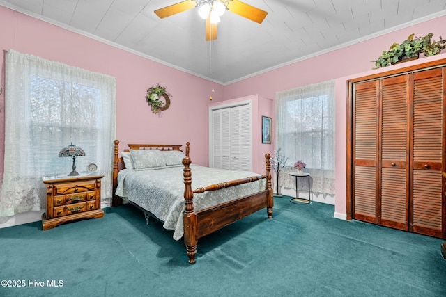 carpeted bedroom with crown molding, two closets, and ceiling fan