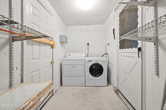 clothes washing area featuring washing machine and dryer and a textured ceiling