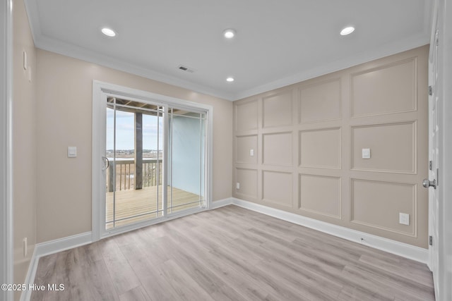 spare room featuring crown molding and light hardwood / wood-style floors