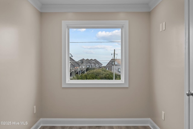 spare room with wood-type flooring and ornamental molding