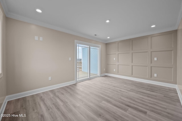 spare room with light wood-type flooring and crown molding