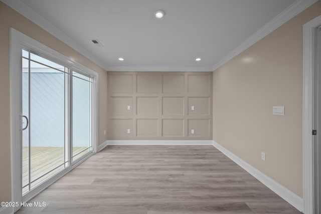 spare room with light wood-type flooring, plenty of natural light, and crown molding